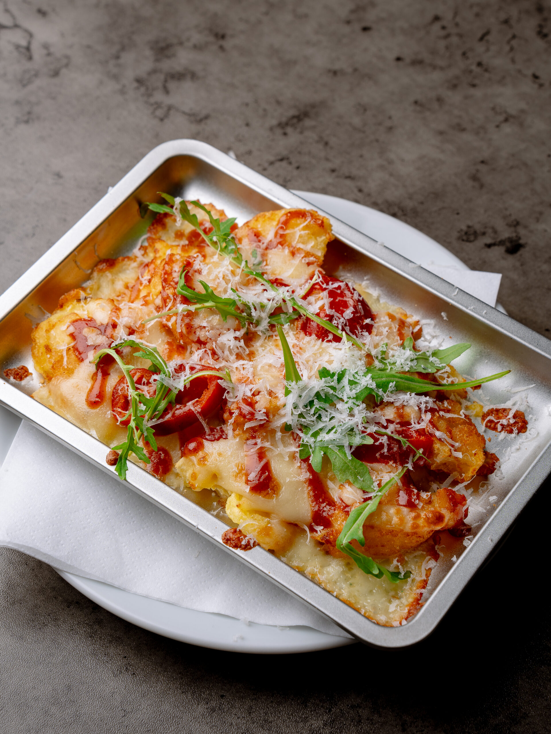 Dynamite Chicken and Cheese Bake at Nesso Coffee Leeds with spiced chicken, rösti potatoes, melted cheese and firecracker sauce